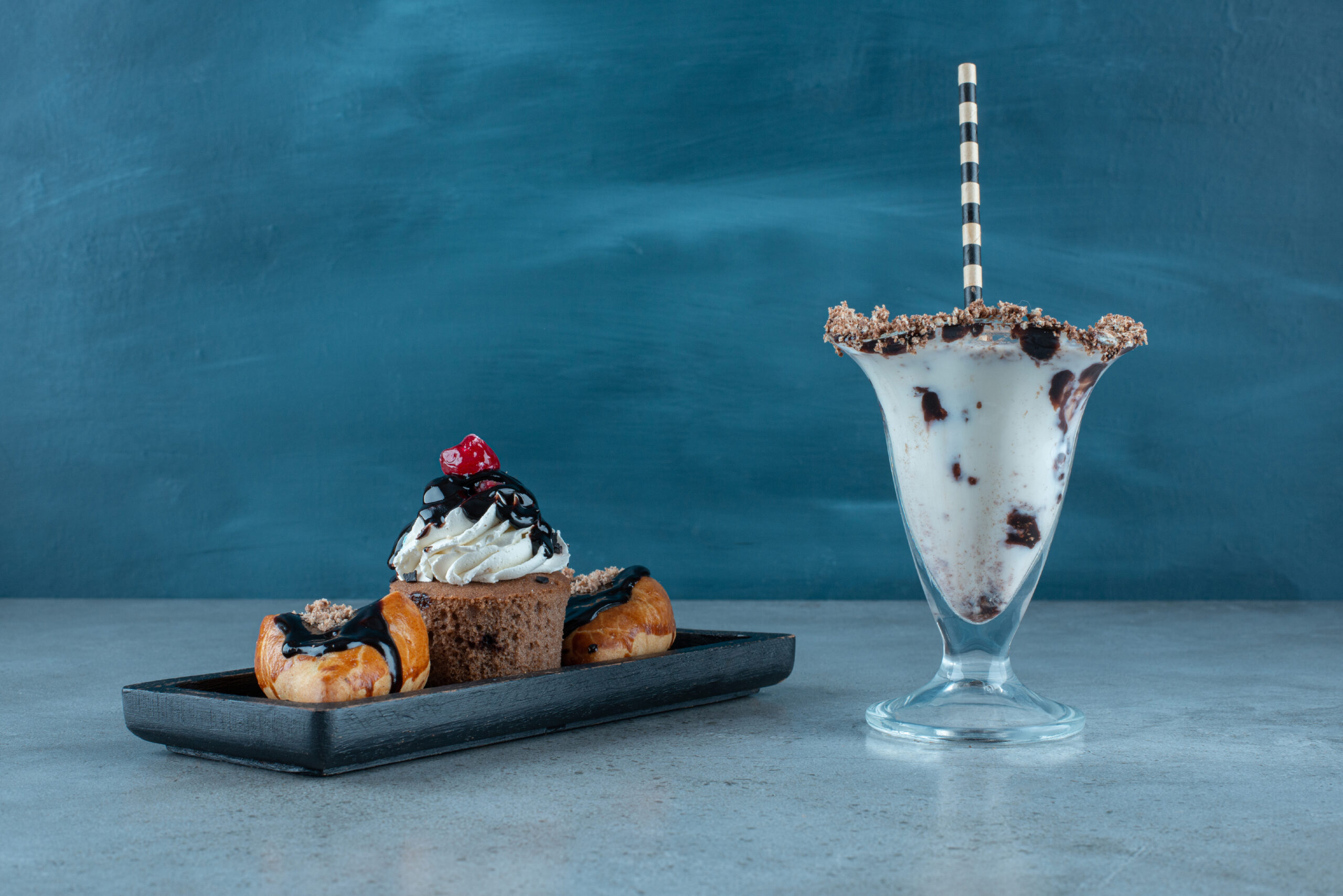 Delicious sweet drink with cupcakes on a dark board. High quality photo