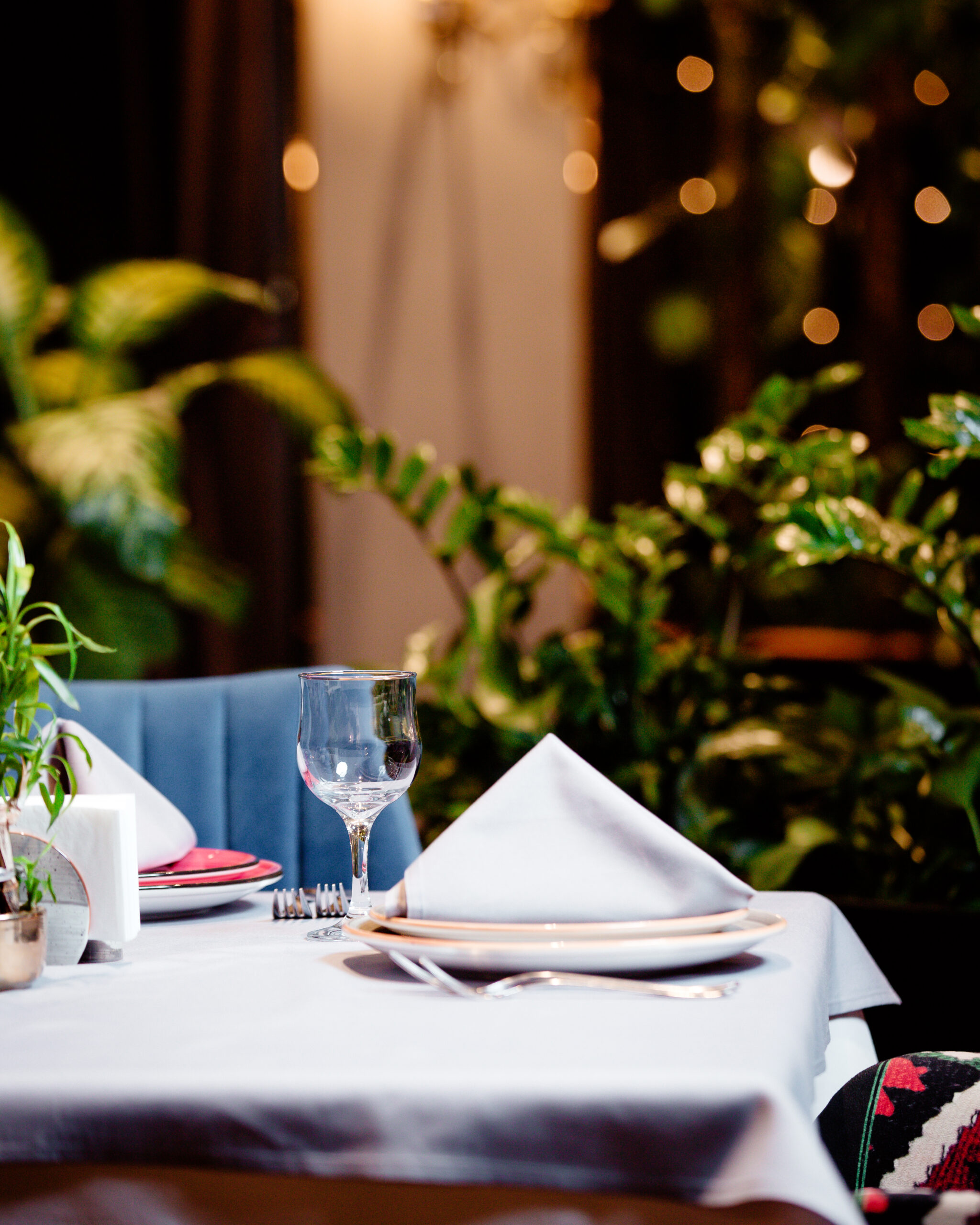 half of the empty restaurant table with plate glass and cutlery